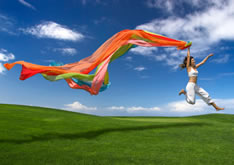 photo shows woman leaping whilst holding flowing coloured streamers out behind her - to give the impression of moving forwards through re training after being made redundant